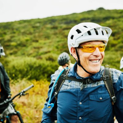 Portrait of smiling senior man hanging out with friends before early morning mountain bike ride