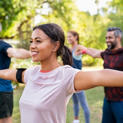 Mixed race woman exercising in park with mature friends