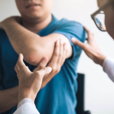 Physical therapists are checking patients elbows at the clinic office room.