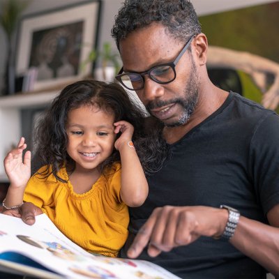 iStock-1284998990-father-reading-to-daughter