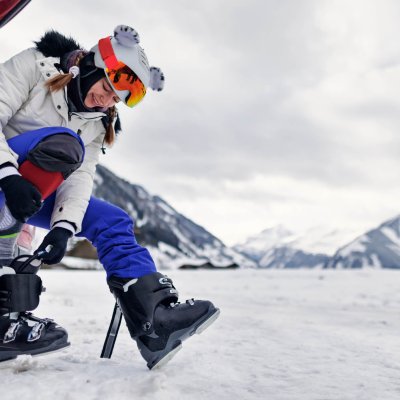 Teenage girl preparing for a day of skiing in Austrian Alps. She is wearing the ski boots.
Canon R5